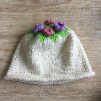 Hand knitted cream beanie with floral embellishment